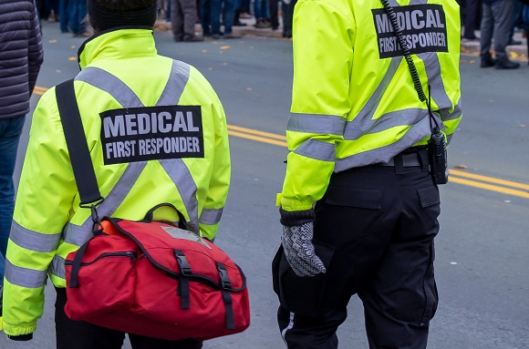 Two,Medical,Responders,Walking,In,A,Street,With,Bright,Yellow